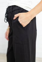 Person wearing black pants with a white background