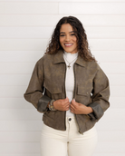 Woman wearing a brown jacket over a white shirt with a white background