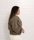 Woman wearing a brown jacket against a white background