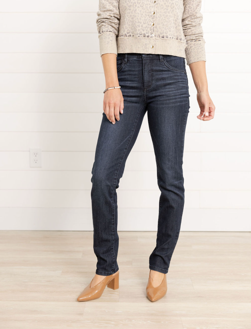 Person wearing dark blue jeans and a light-colored sweater on a white background